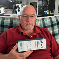 Man holding Kinora packaging at home
