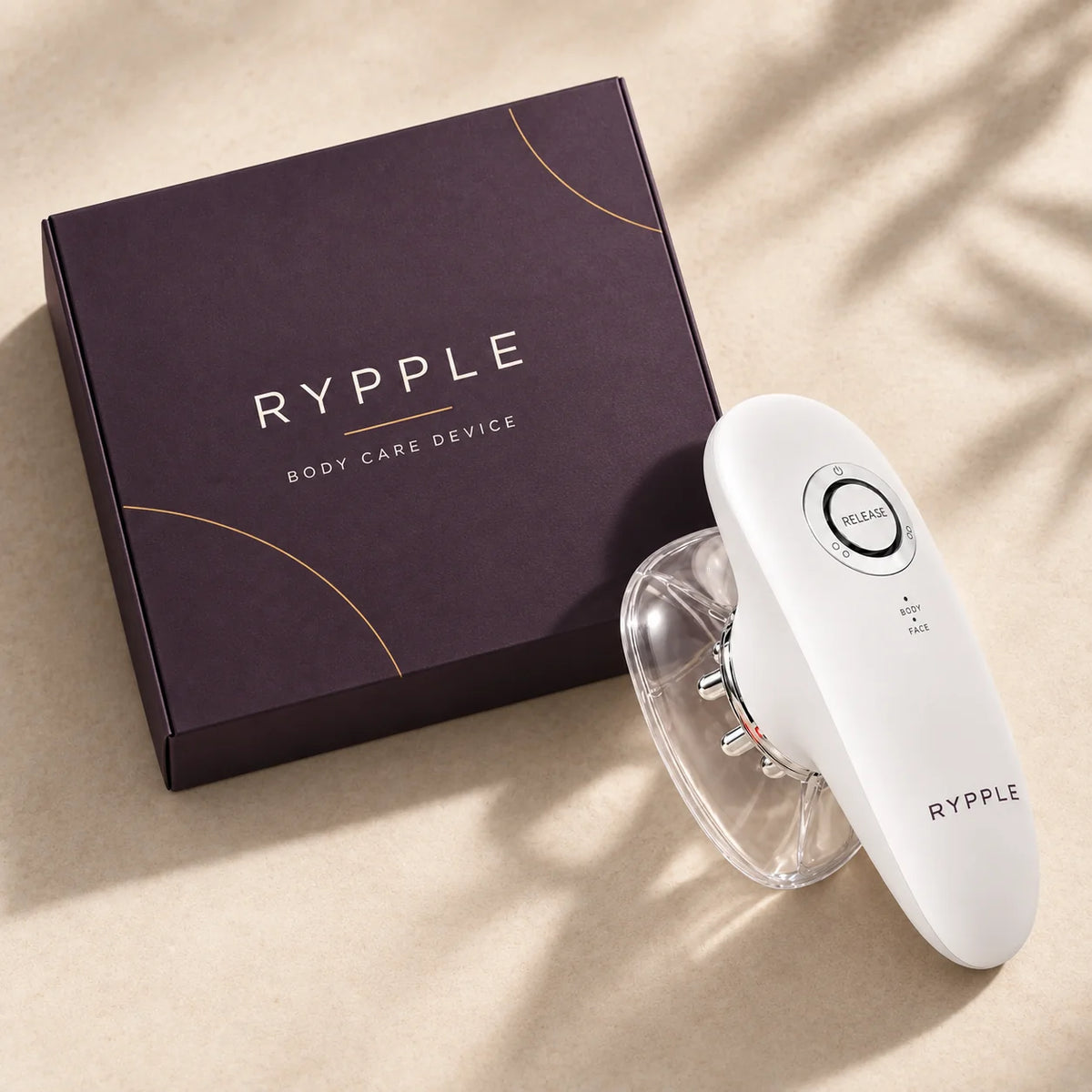 Overhead view of RYPPLE body care device with one clear cup and branded box
